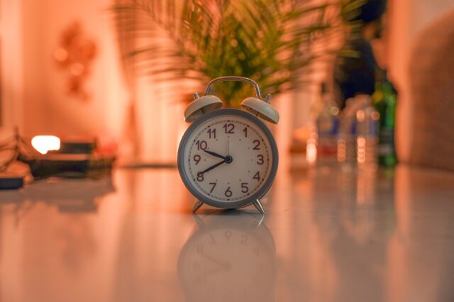 Vintage,Alarm,Clock,On,Table,With,Warm,Indoor,Lighting.,Retro reloj